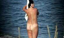 Nudista cu sânii naturali își arată corpul pe o plajă pustie de nudiști