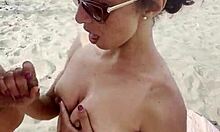 Una bella ragazza europea gode di più mani su una spiaggia di nudisti